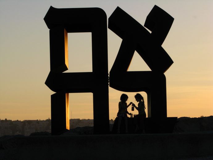 Friends enjoying sunset and sharing a drink at the Ahava (אהבה) Statue.